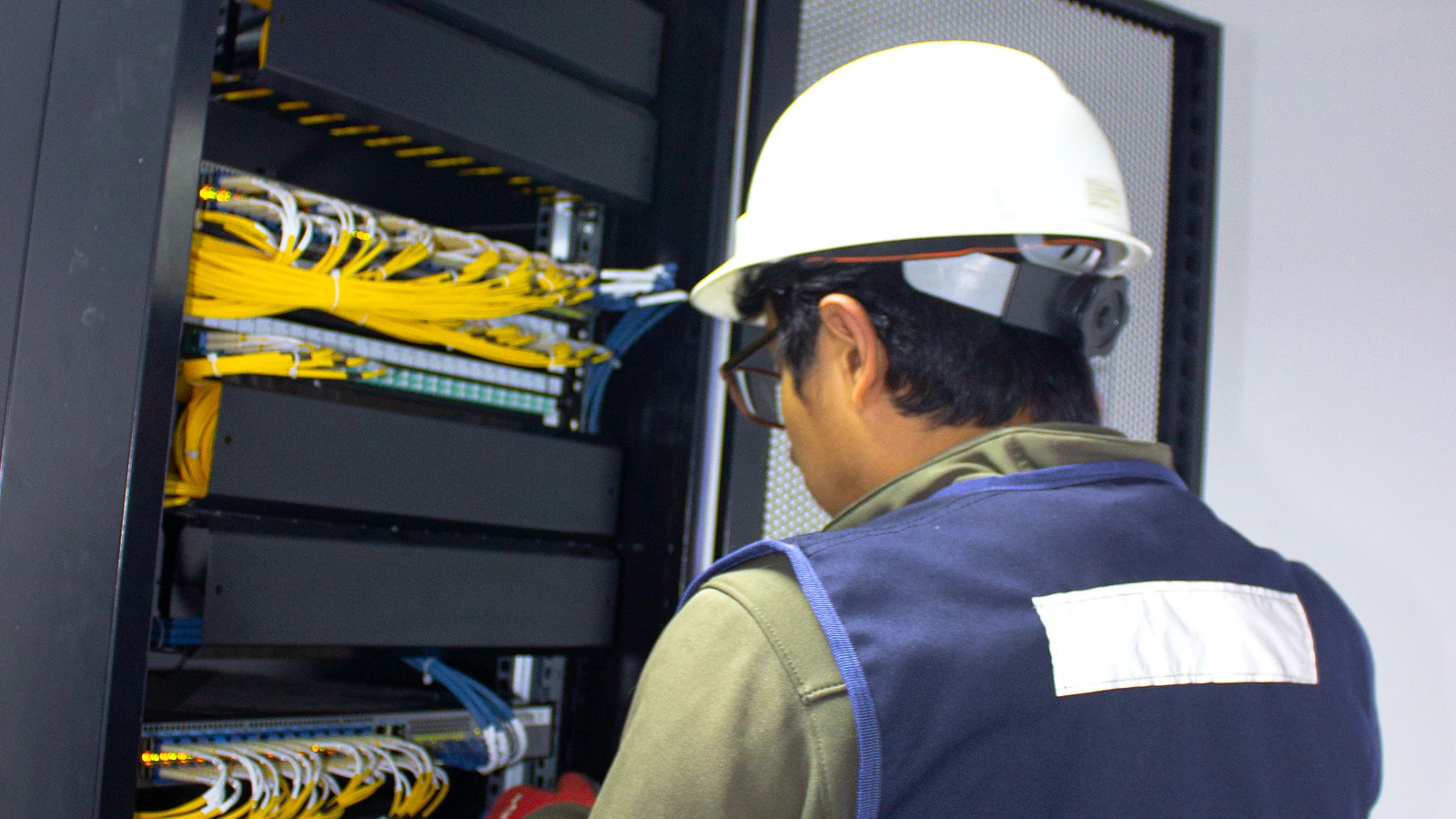 Técnico de GRUPO GAAN instalando y verificando equipamiento en gabinete