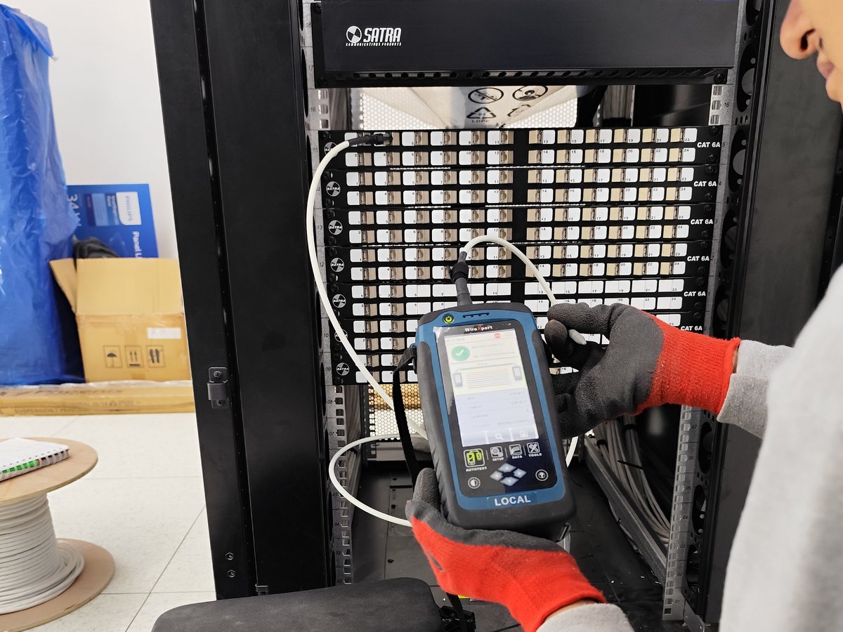 Equipo WireXpert conectado a patch panel durante la certificación de cableado estructurado