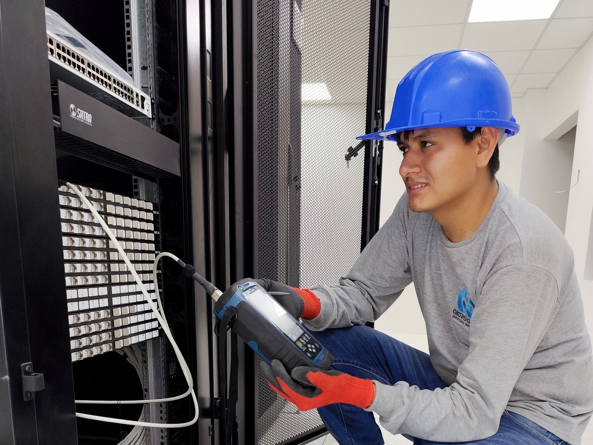 Técnico de GRUPO GAAN certificando cableado estructurado con WireXpert en gabinete de comunicaciones