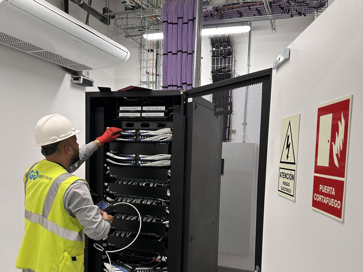 Técnico de GRUPO GAAN realizando pruebas de cableado en una sala técnica hospitalaria